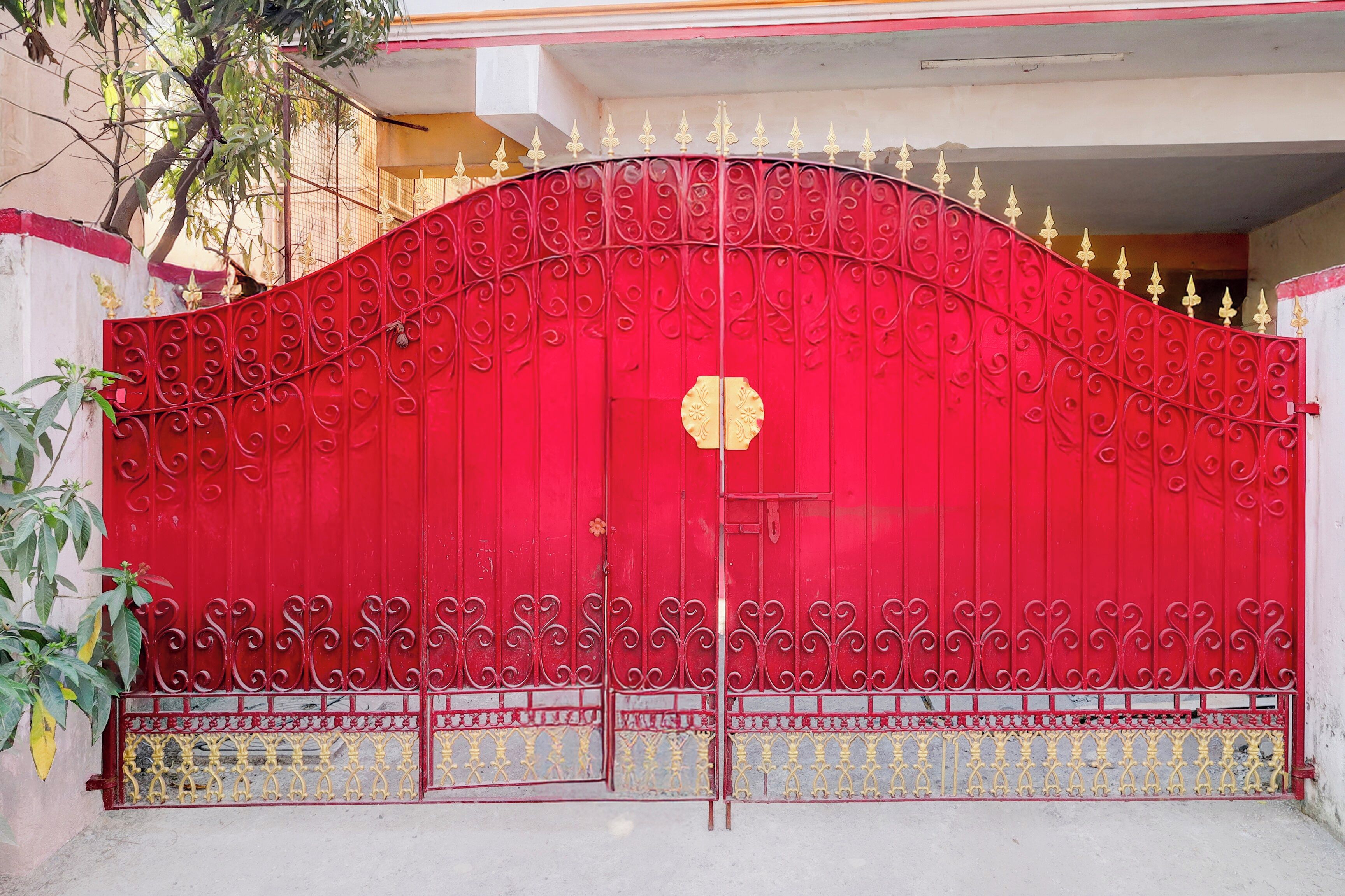 A red metal gate with intricate designs and a decorative keyhole.