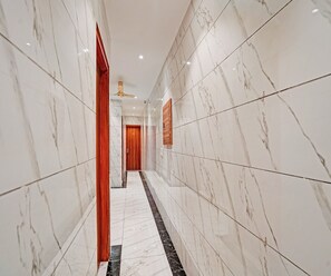 A corridor with marble walls and a black and white tiled floor. - Luxury Hotel Retirement Home (Kalka)