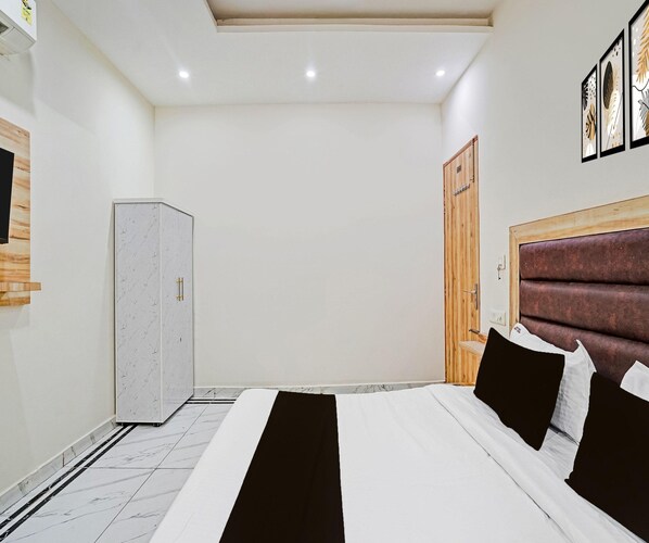 A bedroom with a bed, a wardrobe, and a door. - Luxury Hotel Retirement Home (Kalka)
