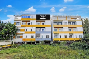A multi-story building with a signboard indicating it's a company-serviced collection.