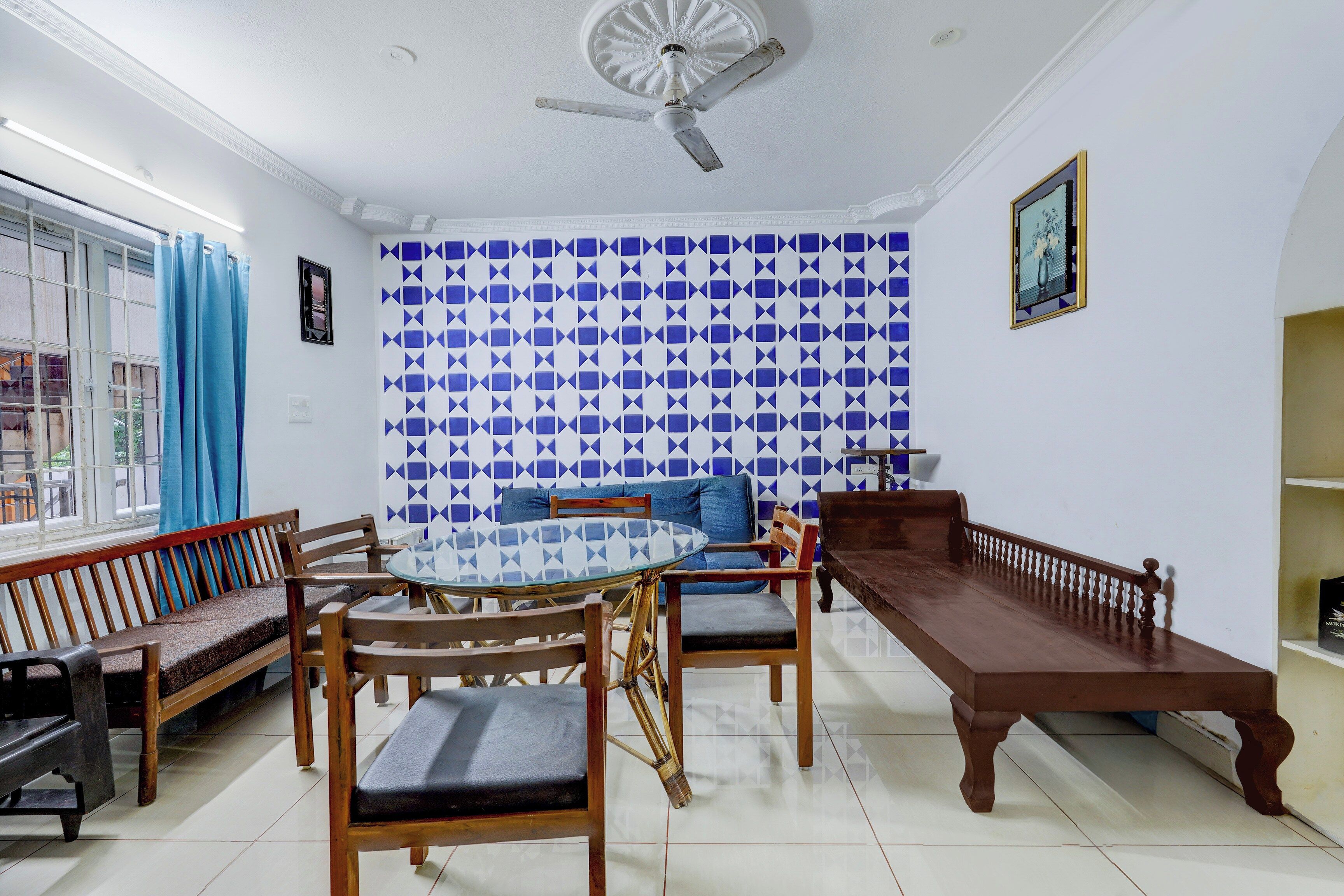 A room with a dining table surrounded by chairs, a sofa, and a wooden bench.
