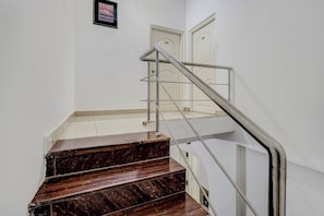 A staircase with a metal handrail leading to an upper floor.