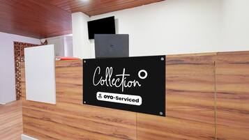 Una mesa de recepción con un cartel que dice 'Collection' y 'Oyo-Serviced'.
