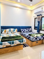 Quarto com uma cama grande, uma cama menor e um banco embutido.
