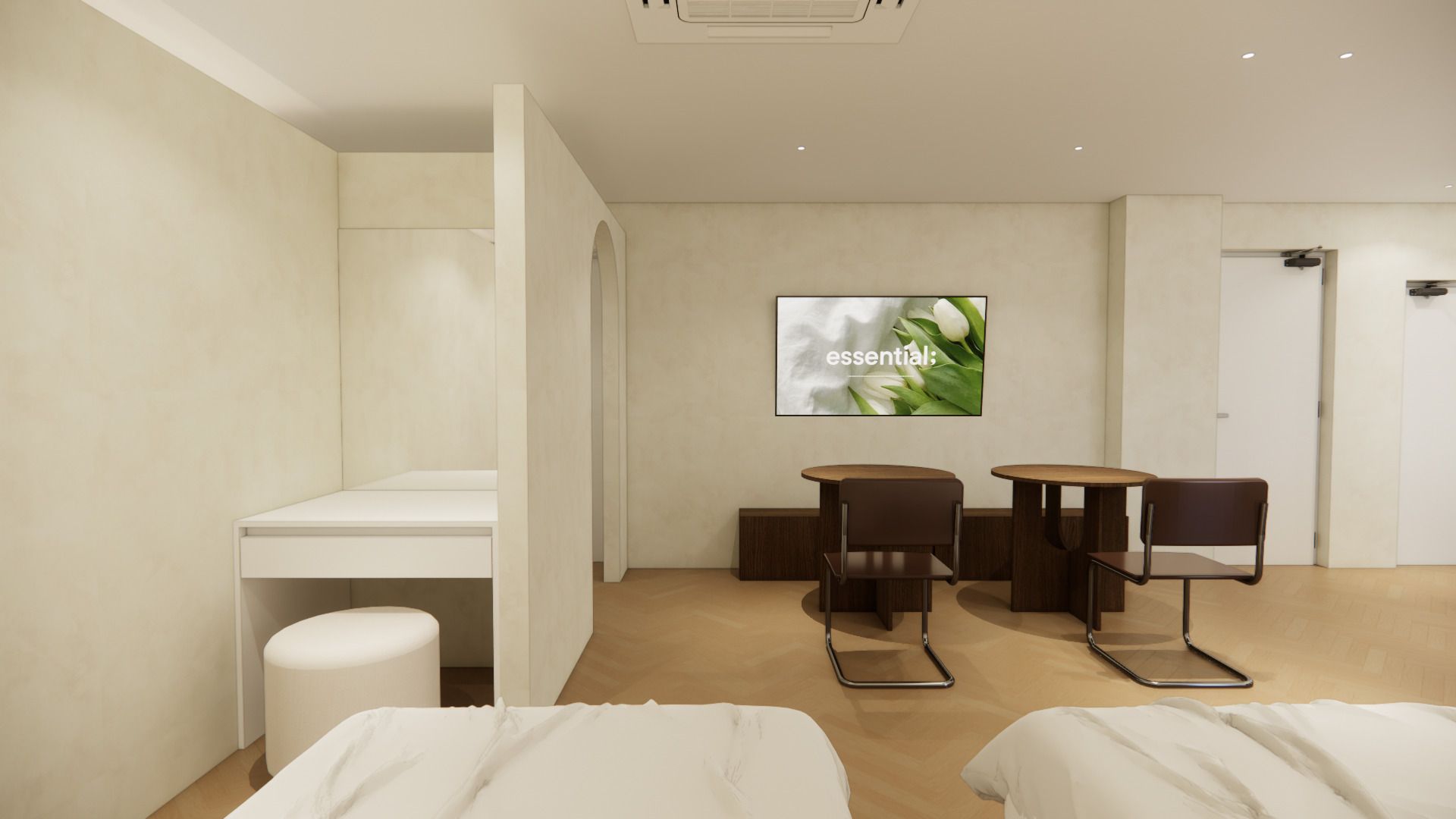 Habitación de hotel moderna con una cama, un escritorio, dos sillas y un televisor mostrando 'essential:' en la pared.