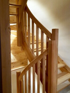 Eine Holztreppe mit Handlauf, die zu einer oberen Etage führt.