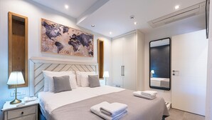 Een moderne slaapkamer met een groot bed, nachtkastjes, een wanddecoratie met een kaart, een spiegel en een garderobe.