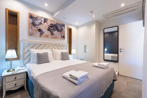 Ein modernes Schlafzimmer mit einem großen Bett, Nachttischen, einem Wandbild mit einer Karte, einem Spiegel und einem Kleiderschrank.