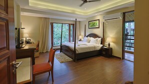 Une chambre spacieuse avec un grand lit, un ventilateur de plafond et une vue sur l’extérieur grâce à une porte coulissante.