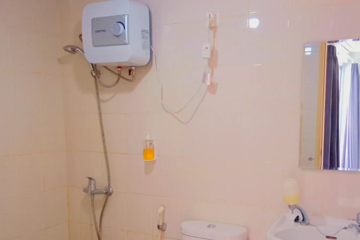 Ein Badezimmer mit Toilette, Waschbecken, Dusche und Toilettenpapierhalter.