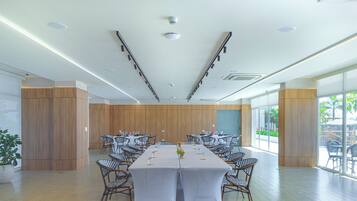 Une salle de conférence avec une longue table, des chaises et une grande fenêtre.