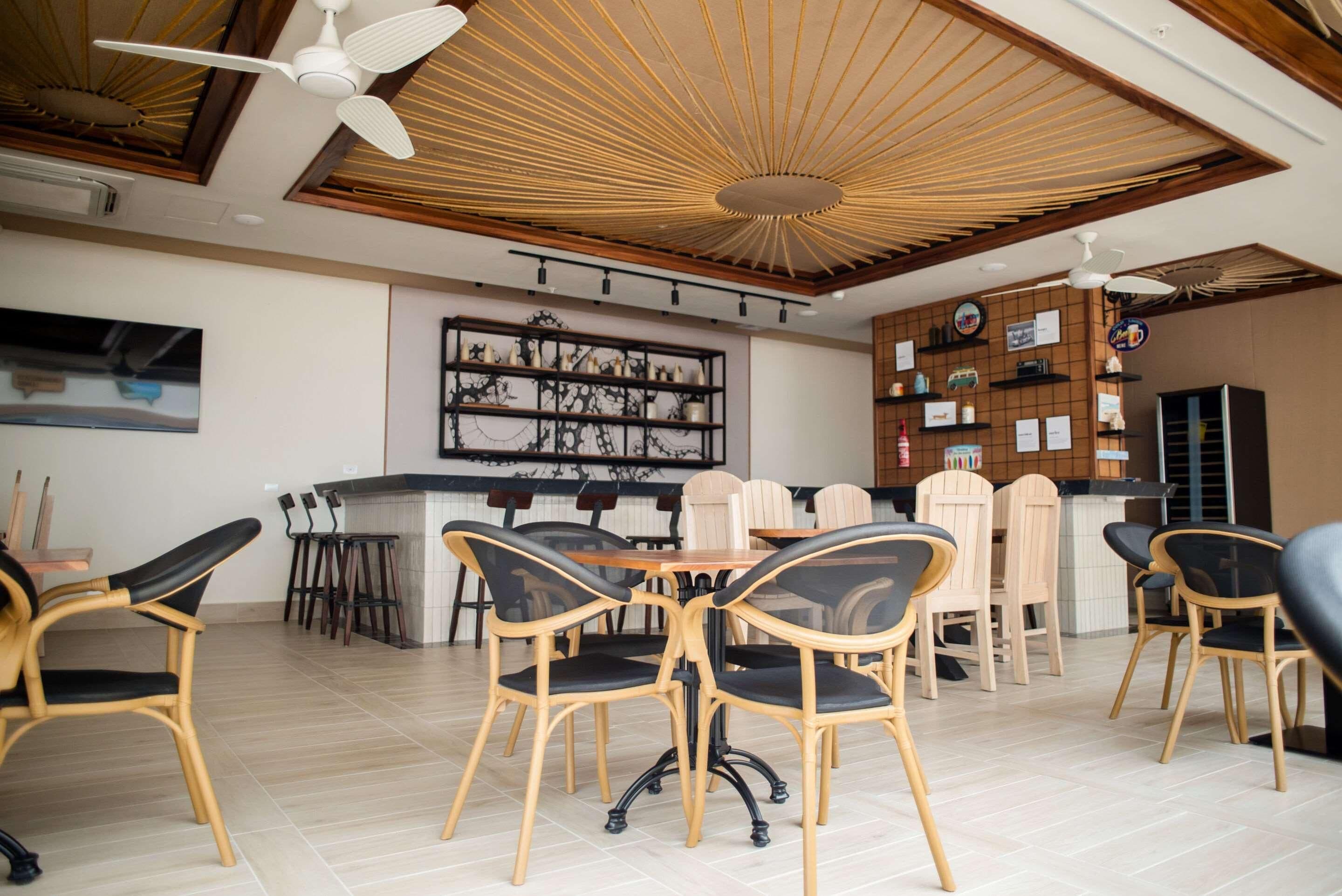 A modern dining area with a central table, chairs, and a ceiling fan.