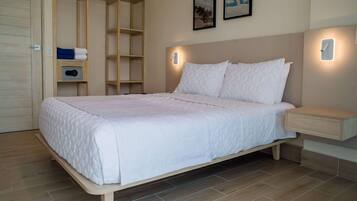 A bedroom with a bed, bedside tables, a wardrobe, and a wall-mounted air conditioning unit.