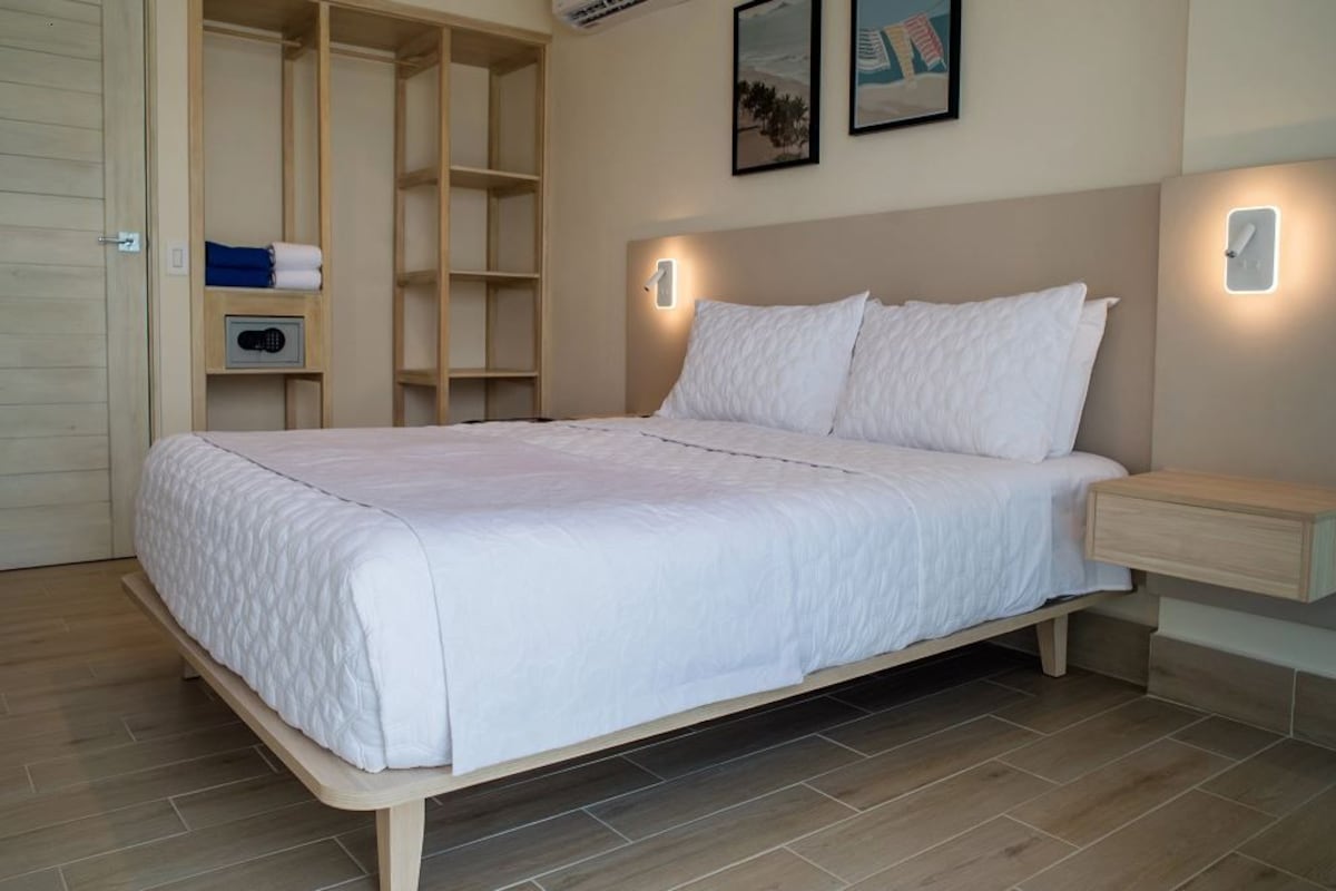 A bedroom with a bed, bedside table, and a wardrobe with shelves.