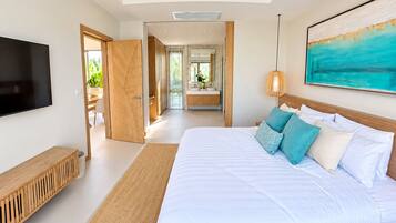 A modern bedroom with a large bed, a TV, and a painting on the wall.