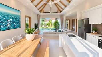 A modern kitchen with a central island, white cabinetry, and a ceiling fan.