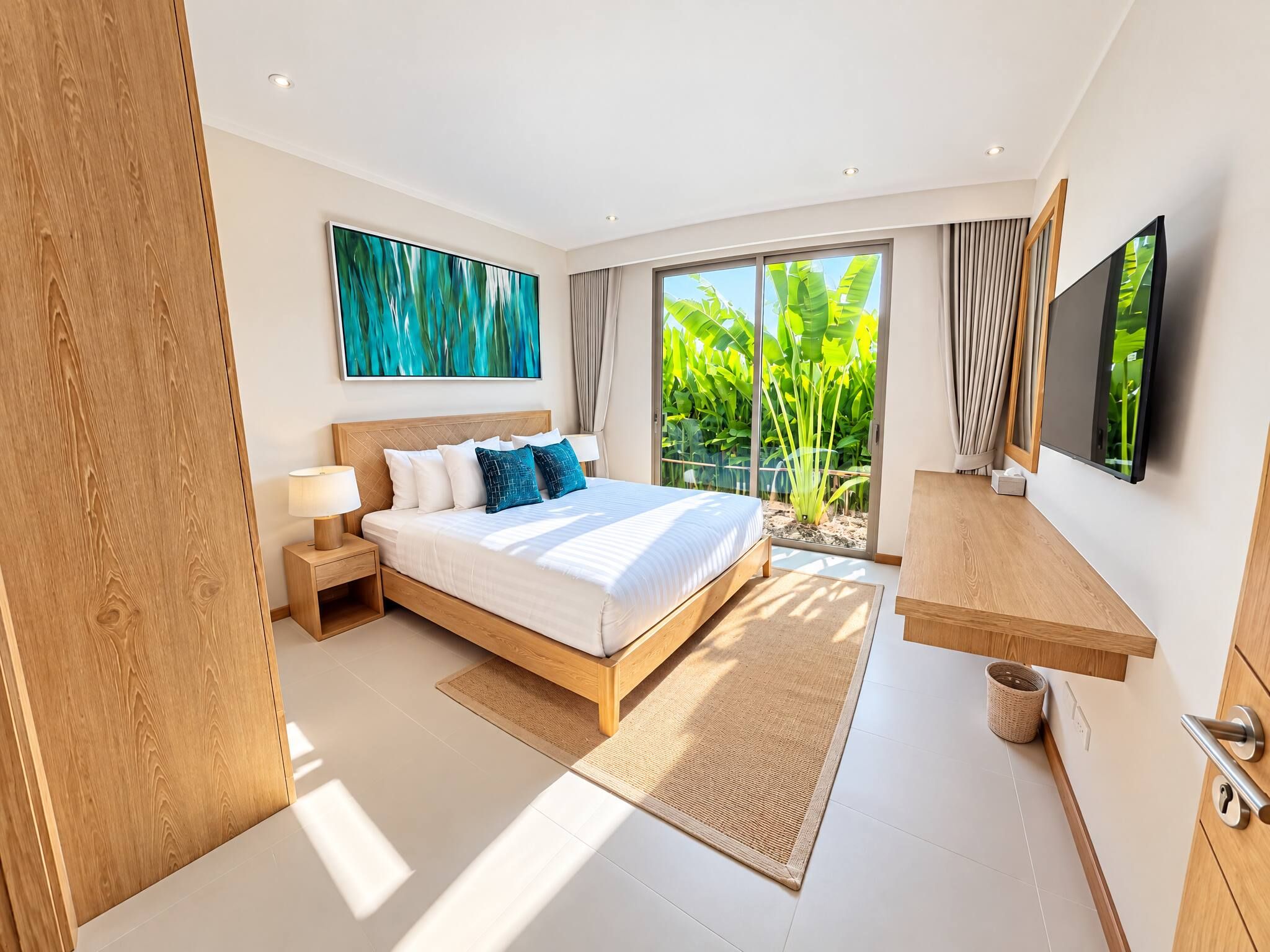 A modern bedroom with a large bed, a flat-screen TV, and a view of greenery through the window.