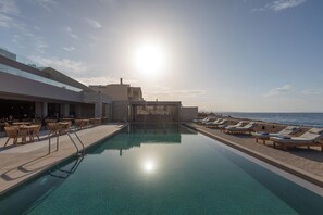 A poolside area with lounge chairs and a bar, overlooking the sea. - Castello Boutique Suites By The Sea (Agios Nikolaos)