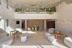 A spacious lobby with a modern chandelier, seating arrangements, and a central table. - Castello Boutique Suites By The Sea (Agios Nikolaos)