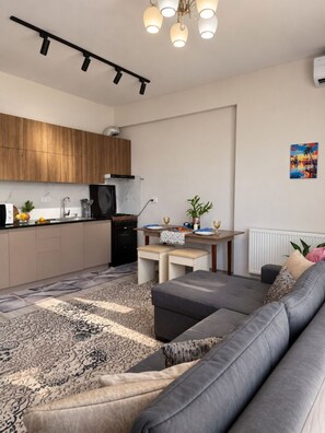 A modern living space with a kitchen, dining area, and seating area. - Zarafshan 60 (Tashkent)