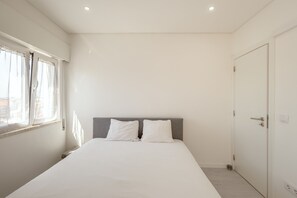 Un dormitorio con cama, ventana y puerta.