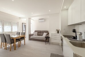 A modern kitchen with a built-in oven and a coffee machine. - Caparica Sunny Apartment by Homing (Almada)