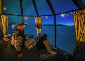 A room with a large window offering a view of the sky and a body of water. - Peace & Quiet Hotel Kiruna (Kiruna)