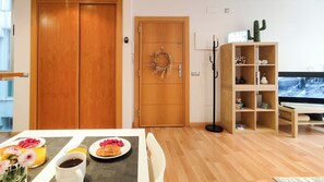 A living room with a wooden door, a television, and a bookshelf. - Casa Picaso by Sharinco (Málaga)