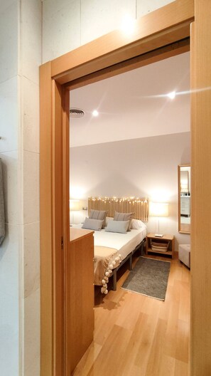 A bedroom with a bed, bedside tables, a mirror, and a wooden door frame. - Casa Picaso by Sharinco (Málaga)
