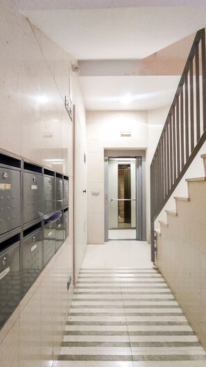 A hallway with metal lockers, a staircase, and a door leading to an elevator. - Casa Picaso by Sharinco (Málaga)