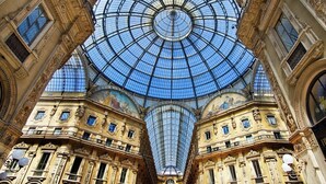 Um edifício ornamentado com uma grande cúpula de vidro e detalhes arquitetônicos elaborados.
