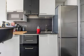 A modern kitchen with a built-in oven, a stainless steel refrigerator, and a coffee machine. - Cap Agde Waterfront (Agde)