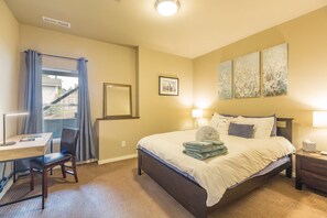 A hotel room with a bed, desk, chair, and artwork on the walls. - Perfect 2-bedroom Guest Suite with AC in welcoming Seattle (Seattle)