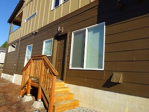 A two-story building with a wooden front porch and a set of stairs leading to the entrance. - Perfect 2-bedroom Guest Suite with AC in welcoming Seattle (Seattle)