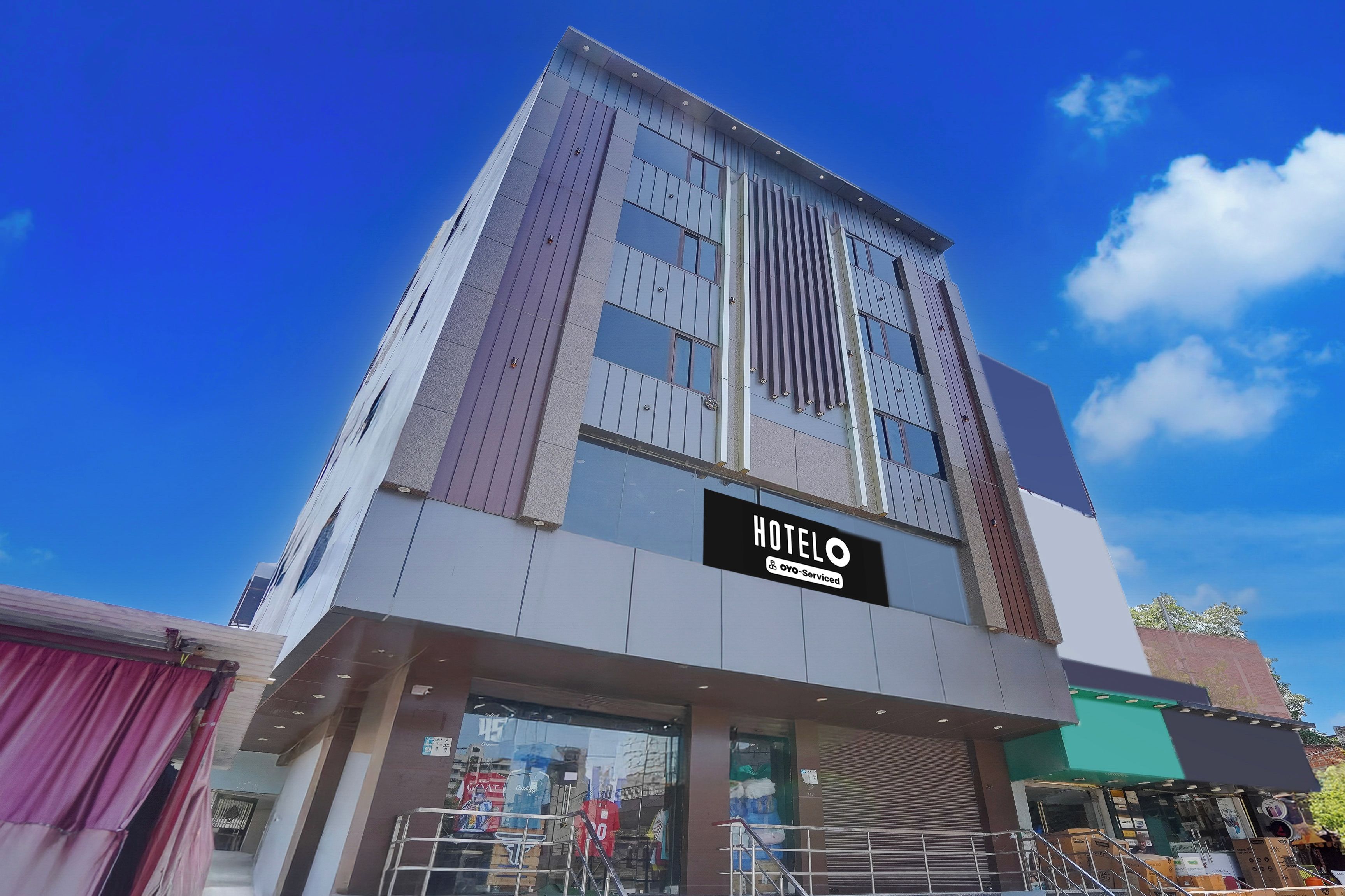 Ett hotell med en modern fasad, en tydlig skylt med texten ”HOTEL” och en väl synlig entré med en trappa.