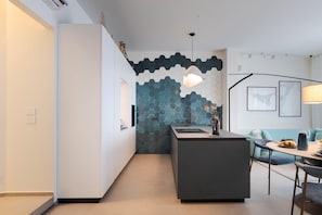 A modern kitchen with a central island, a dining area with a table and chairs, and a living space with a sofa and a coffee table. - Charming sea front apartment with terrace in Mazzarò, Taormina - DICasaInSicilia (Taormina)