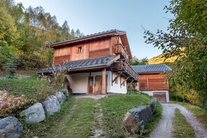 A wooden chalet with a sloped roof, a covered porch, and a stone wall. - Chalet 'Chalet des Loutres' at the foot of the slopes and chairlift, peaceful, panoramic view (Les Deux Alpes)