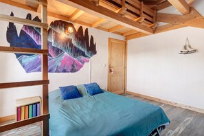 A bedroom with a bed, a wooden ceiling, a door, and a wall with a painting. - Chalet 'Chalet des Loutres' at the foot of the slopes and chairlift, peaceful, panoramic view (Les Deux Alpes)