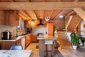 A wooden interior with a kitchen, dining area, and staircase. - Chalet 'Chalet des Loutres' at the foot of the slopes and chairlift, peaceful, panoramic view (Les Deux Alpes)