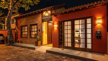 A building with a sign reading 'Villa da Luz' and a wooden door with glass panels.