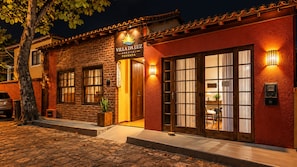 A building with a sign reading 'Villa da Luz' and a wooden door with glass panels.