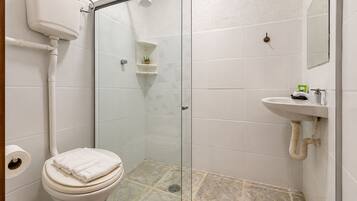 Ein Badezimmer mit Toilette, einer Duschkabine und einem Waschbecken.