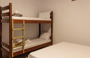 A bunk bed with a ladder, a lower bunk with a pillow, and a mattress on the floor. - Villa da Luz (Porto Seguro)