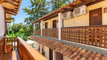 A traditional building with a balcony, air conditioning units, and a wooden door marked with the number 07.
