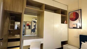 Een moderne slaapkamer met een ingebouwd bureau, een bed en een kledingkast.
