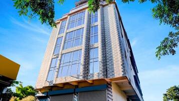 A tall building with multiple windows and a stone facade.