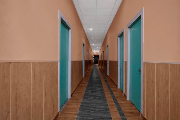 A long hallway with doors on both sides, leading to individual rooms.