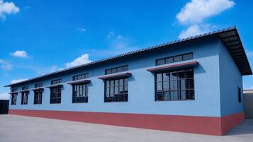 A building with a flat roof, multiple windows, and a red and blue facade.