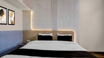 Un dormitorio moderno con una cama, mesitas de noche y decoración en la pared.