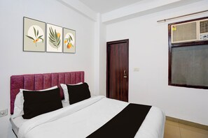 A bedroom with a bed, a door, and three wall-mounted pictures. - Hotel O Gomti Nagar Station (Lucknow)